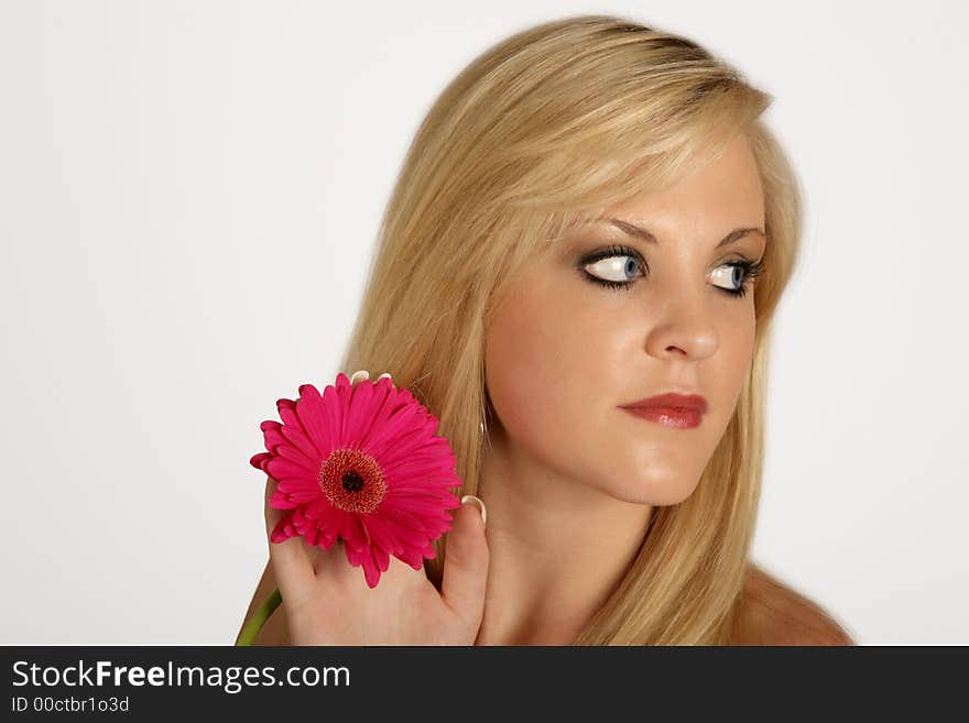 A woman holding in pink flower in her hand. A woman holding in pink flower in her hand