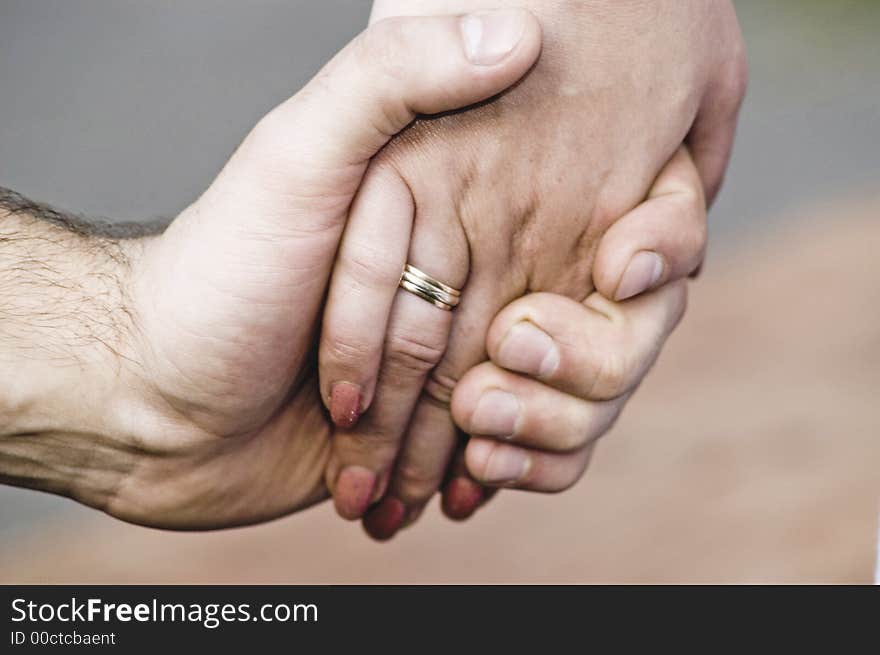 A man's hand pressing a womans hand. A man's hand pressing a womans hand