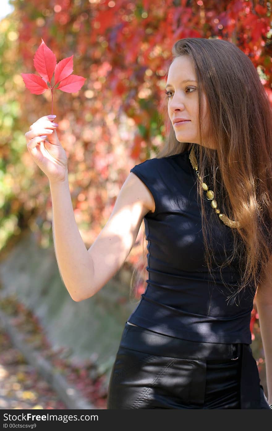 Girl holding a red leaf. Girl holding a red leaf