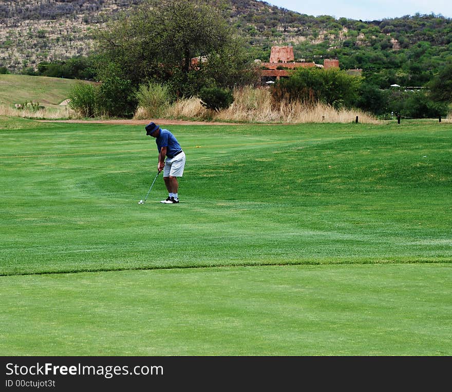 Golfer preparing to hit the ball onto the green. Golfer preparing to hit the ball onto the green.