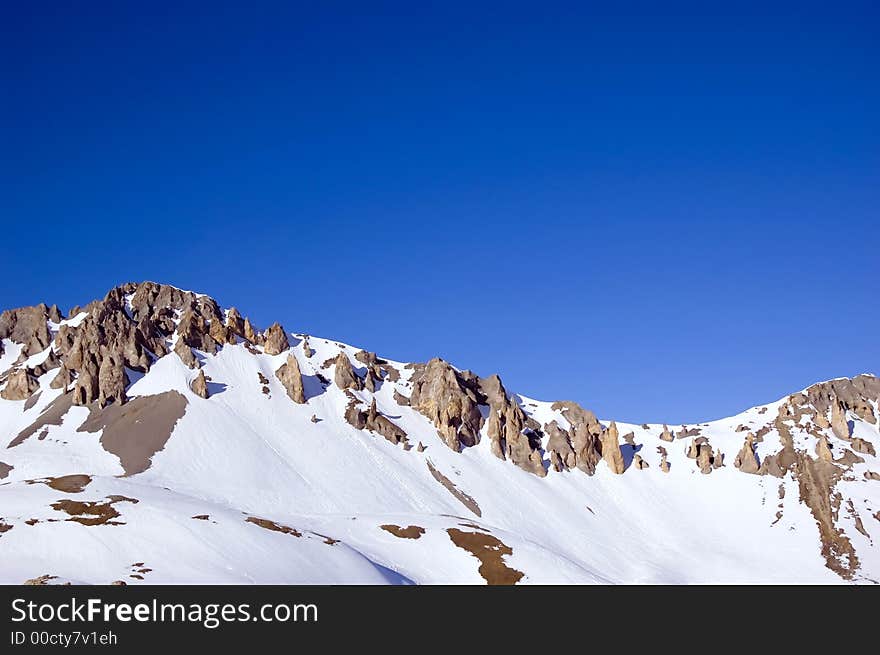 Snowed peaks of a mountain range, a lot of blue for copy-space