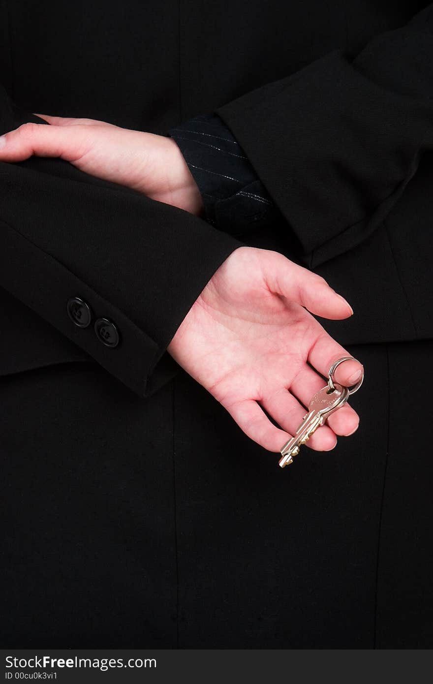 A woman in a black suit holding a set of silver keys