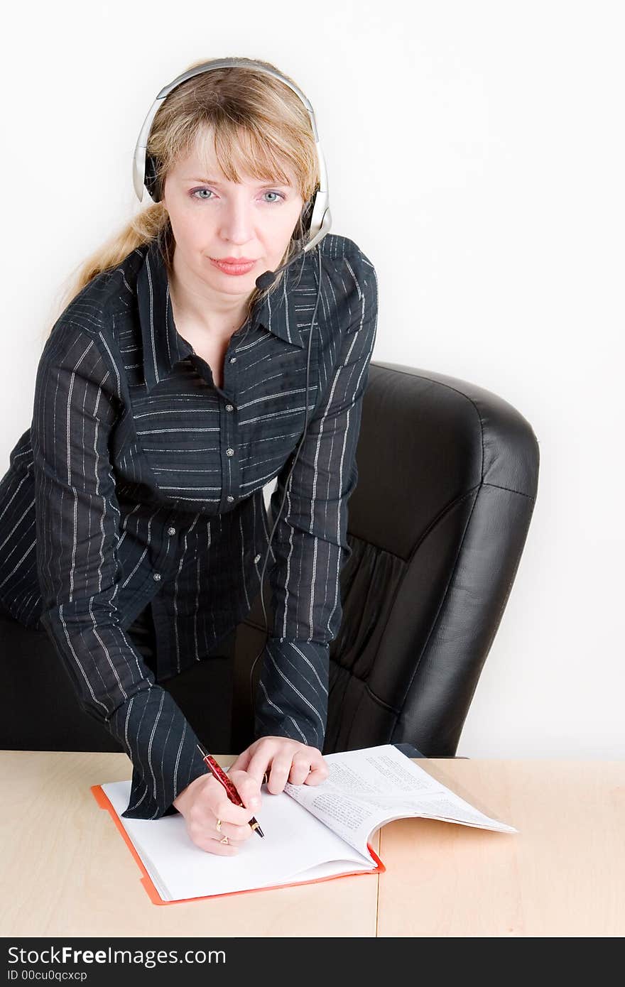 A woman writing whilst on the phone