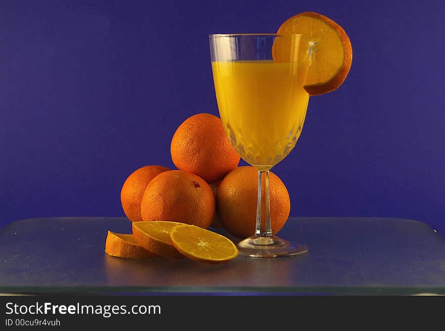 Oranges and orange juice against a blue background