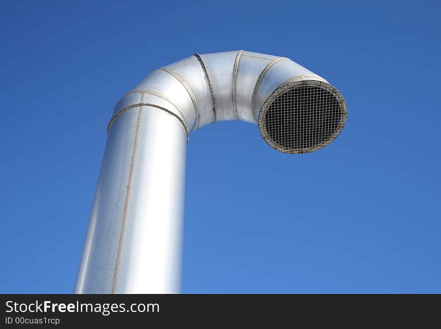 Shiny metallic ventilation pipe on a blue sky background. Shiny metallic ventilation pipe on a blue sky background.