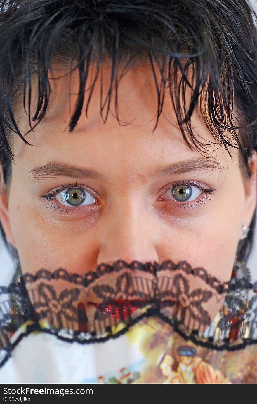 Female face behind a fan close up