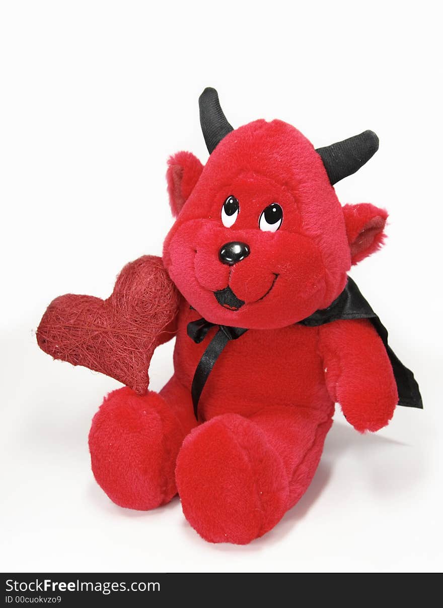 Devil toy with a red heart isolated on white background