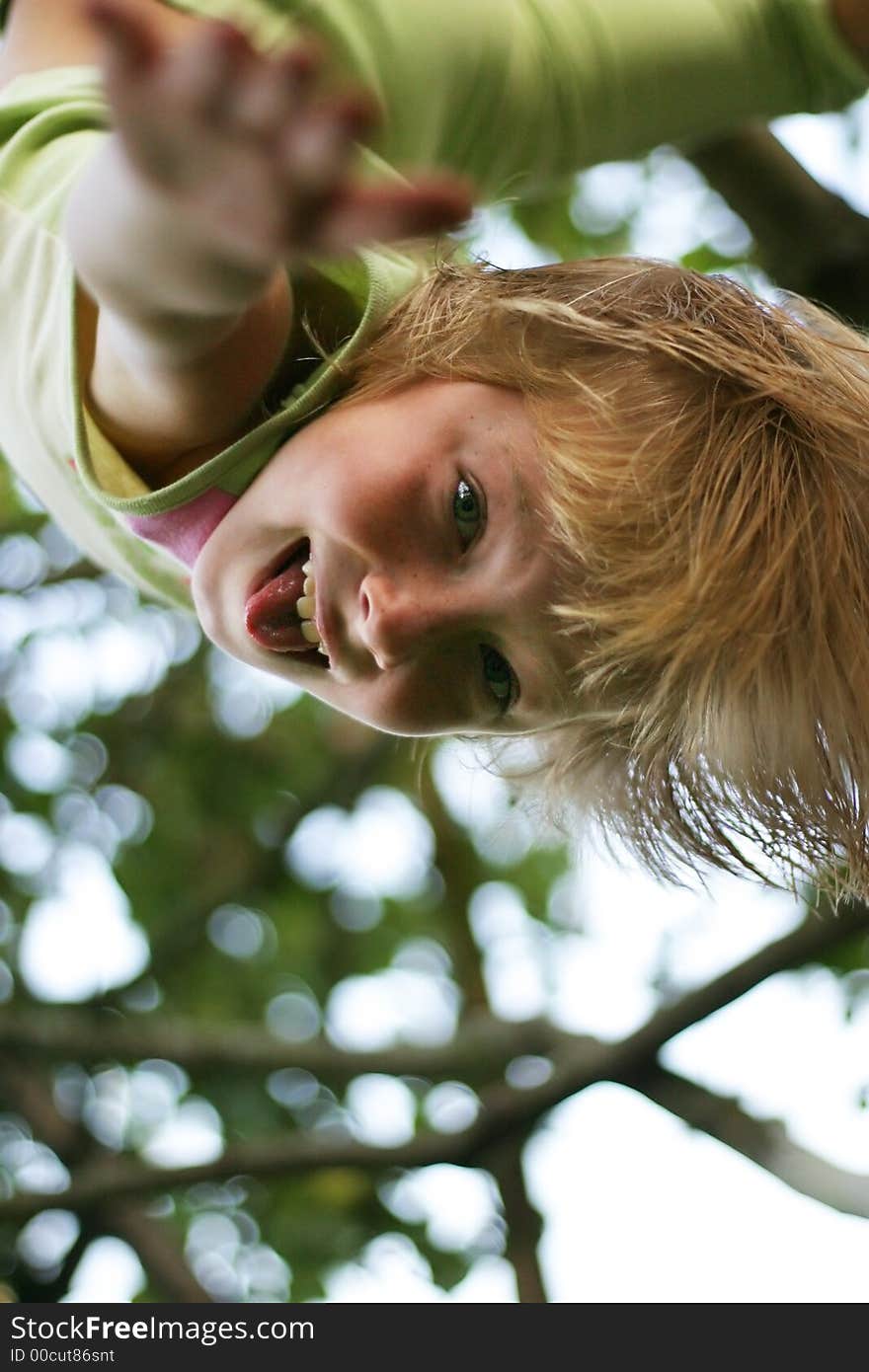 The ridiculous girl hangs on a tree headfirst