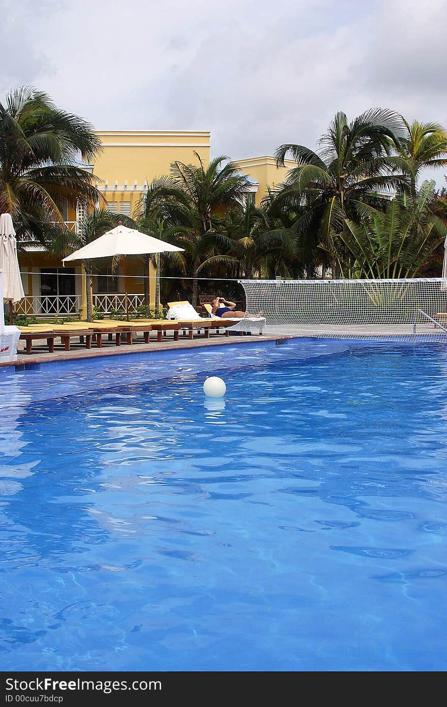 Swimming pool with beach chairs and part of a hotel with hacienda like details in Cancun, Riviera Maya, Quinatan Roo, Mexico, Latin America. Swimming pool with beach chairs and part of a hotel with hacienda like details in Cancun, Riviera Maya, Quinatan Roo, Mexico, Latin America