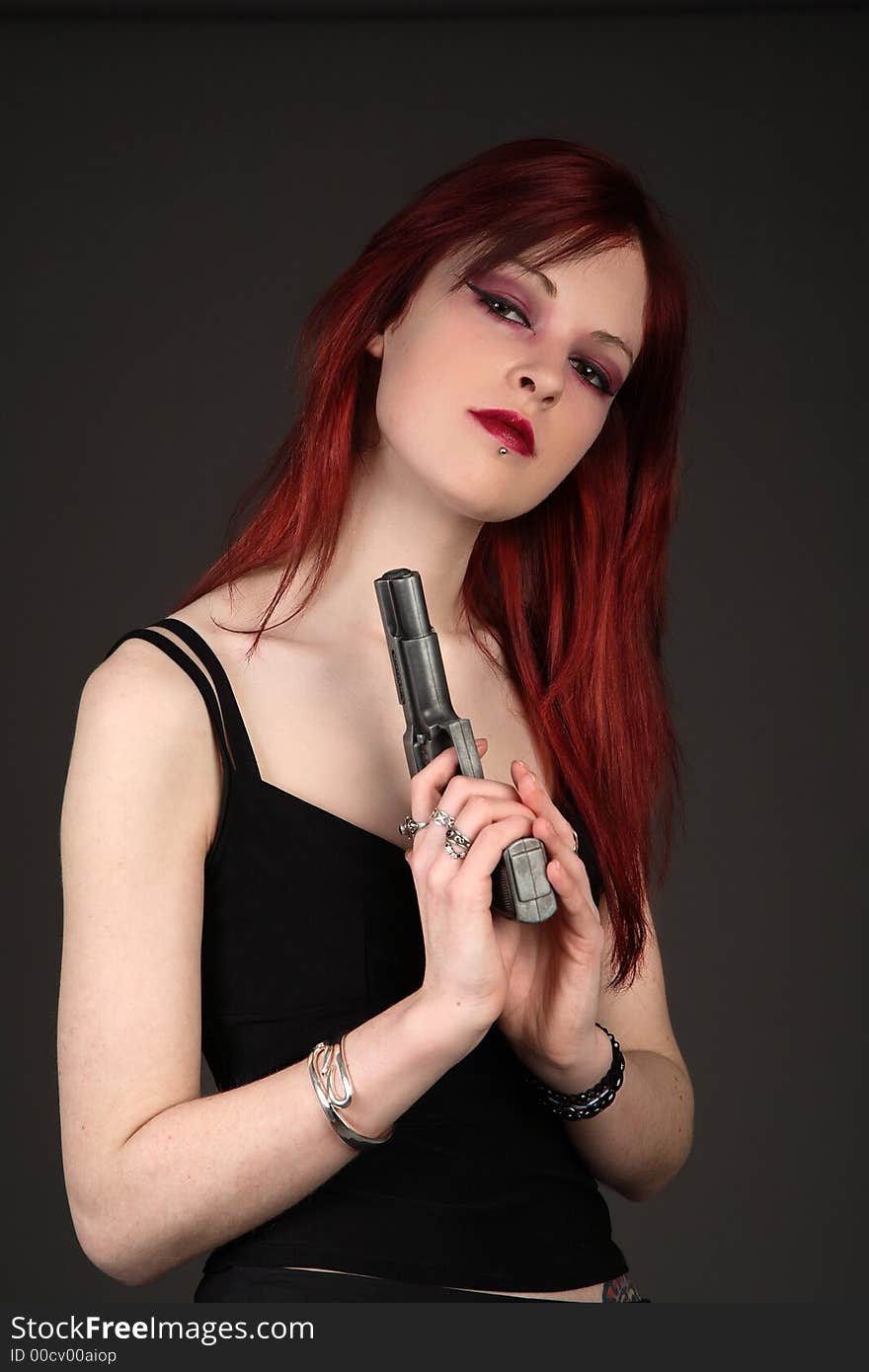 Young redhead woman holding a handgun. Young redhead woman holding a handgun