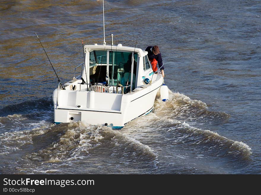 Fisherman moving a fender from his boat. Fisherman moving a fender from his boat