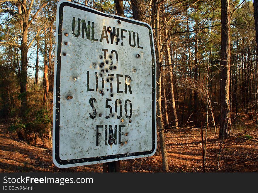 Unlawful to Litter sign riddled with bullets. Unlawful to Litter sign riddled with bullets