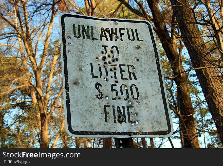 No littering sign - with tons of bullet holes