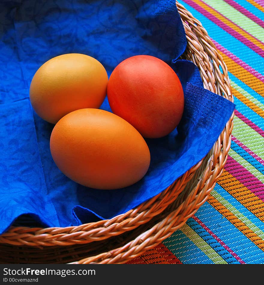 Three eggs in the baskets on striped fabric