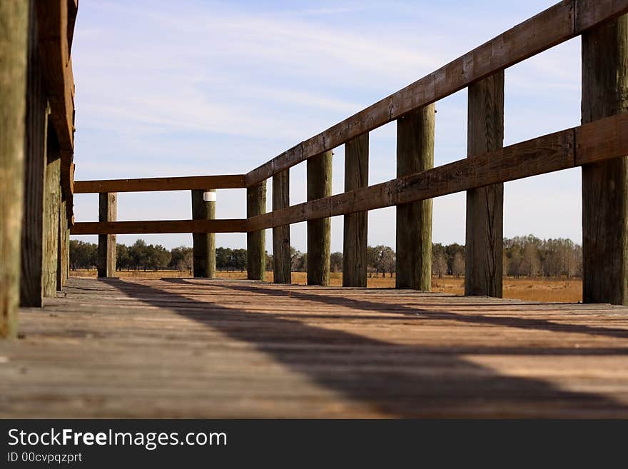 Low view along a boardwalk extending out over dried up lake. Low view along a boardwalk extending out over dried up lake