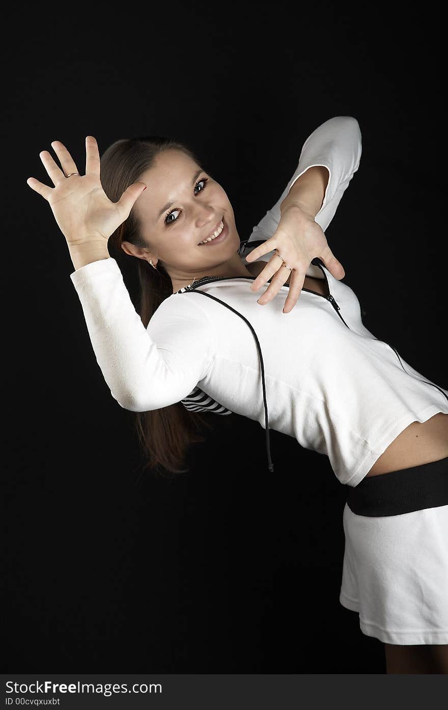 Smiling girl with raised hands in sportive wear on black background. Smiling girl with raised hands in sportive wear on black background