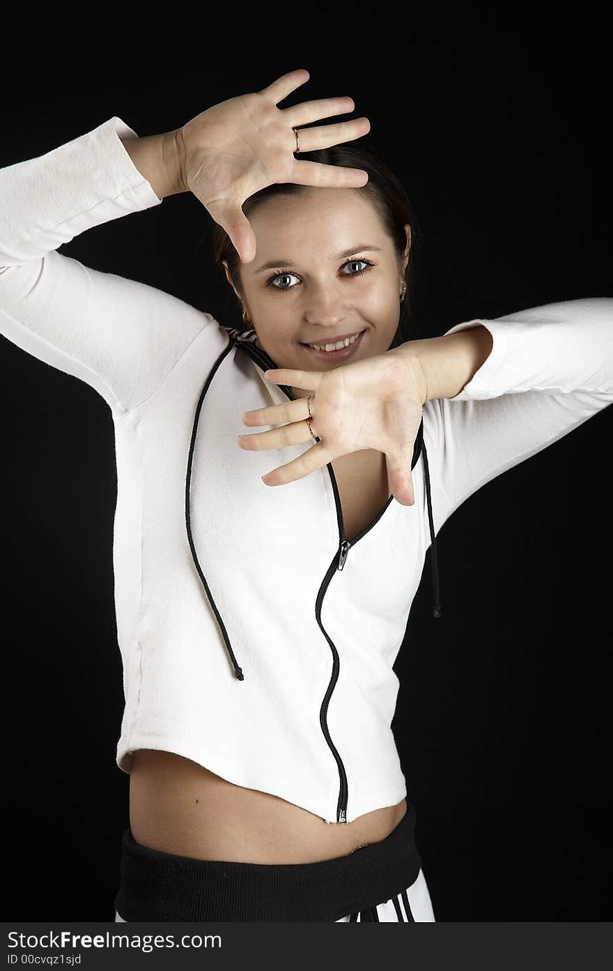 Smiling girl with raised hands in sportive wear on black background. Smiling girl with raised hands in sportive wear on black background