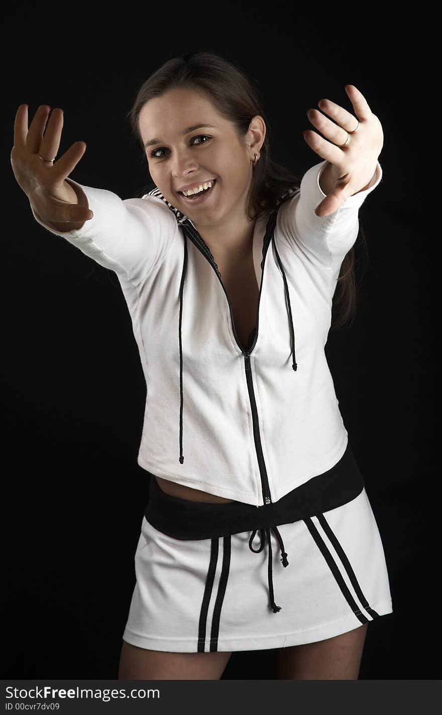 Smiling girl with raised hands in white sportive wear on black background. Smiling girl with raised hands in white sportive wear on black background