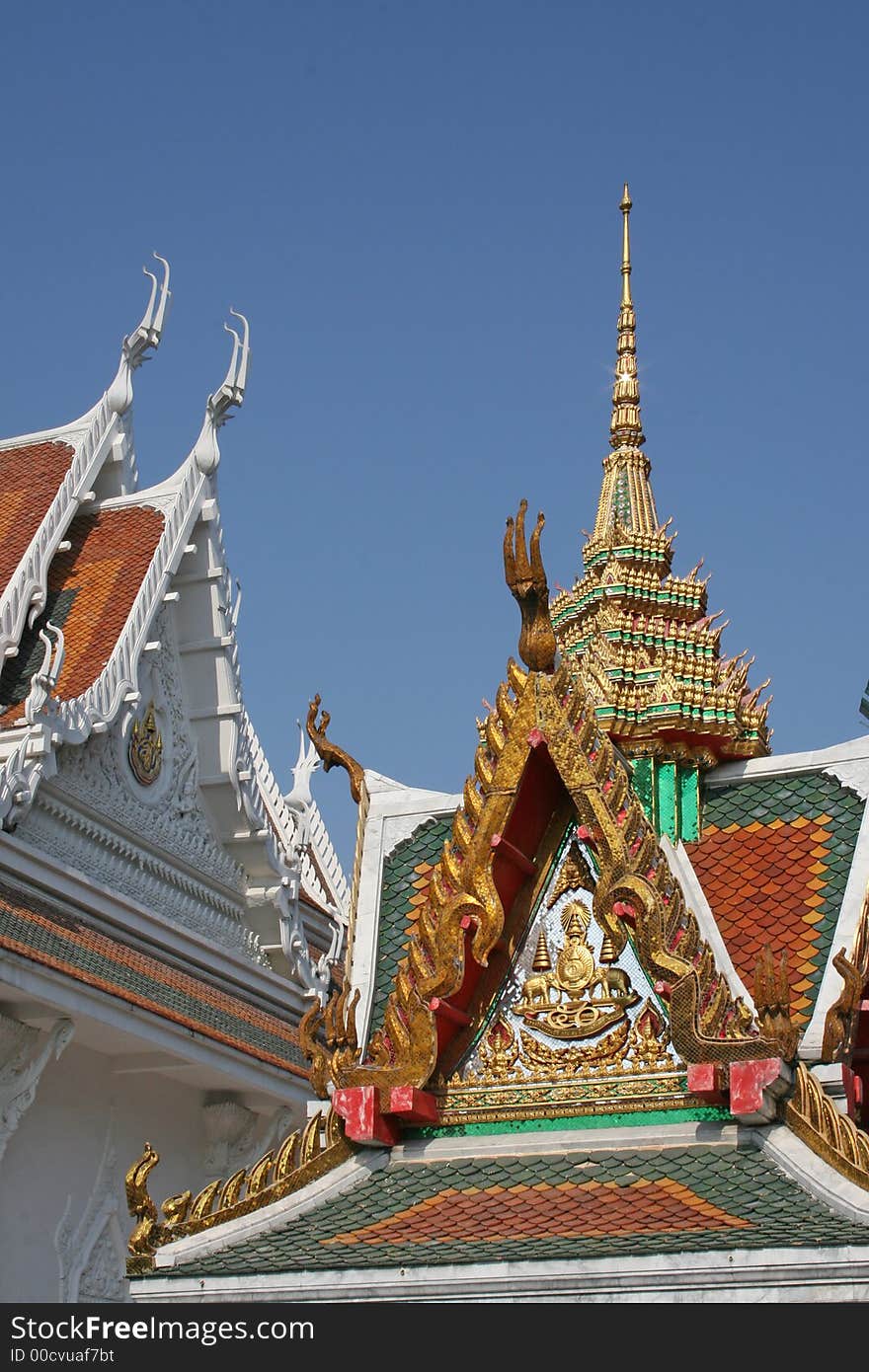 A Buddhist temple with ornate golden decoration against a deep blue sky background