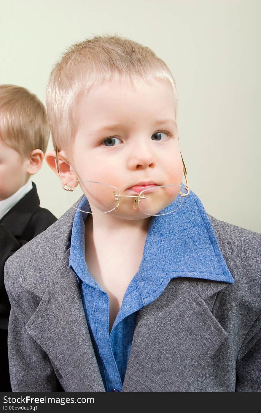 Little boy in business suit with eyeglasses looking into camera. Little boy in business suit with eyeglasses looking into camera