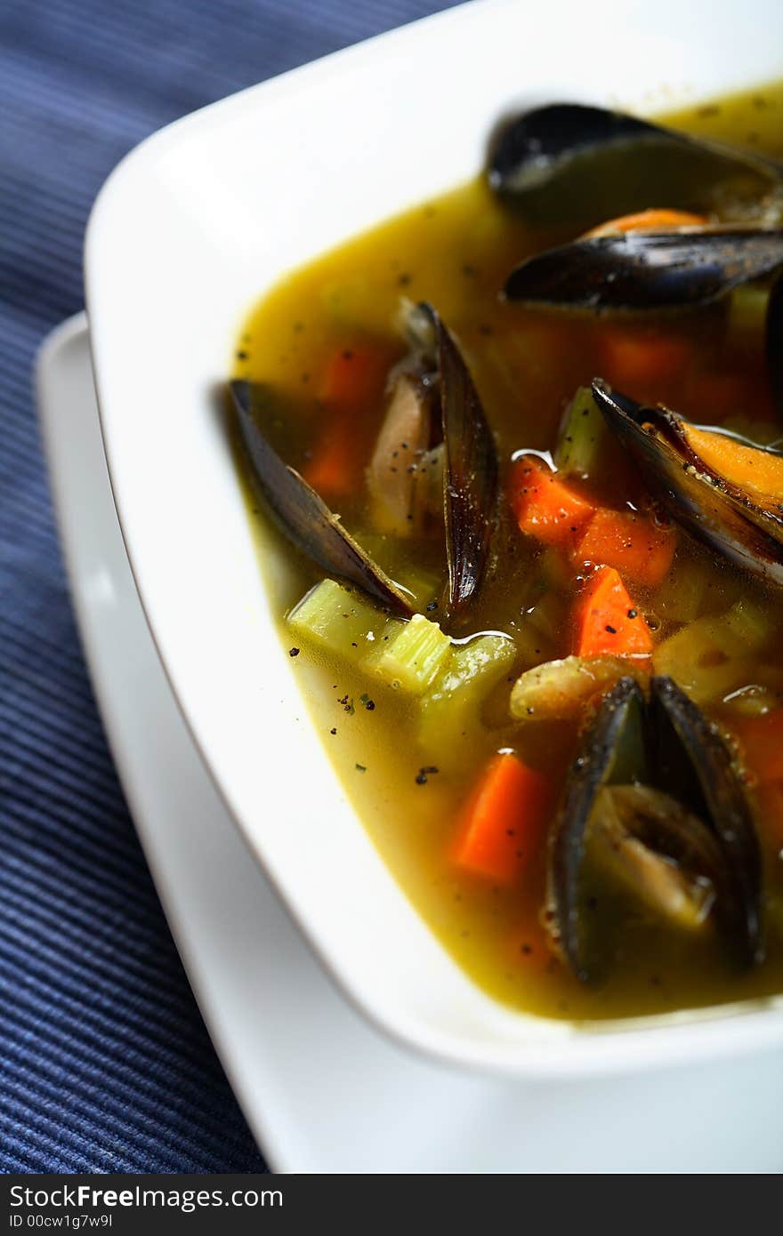 Tasty soup with shellfish and vegetables on the white plate