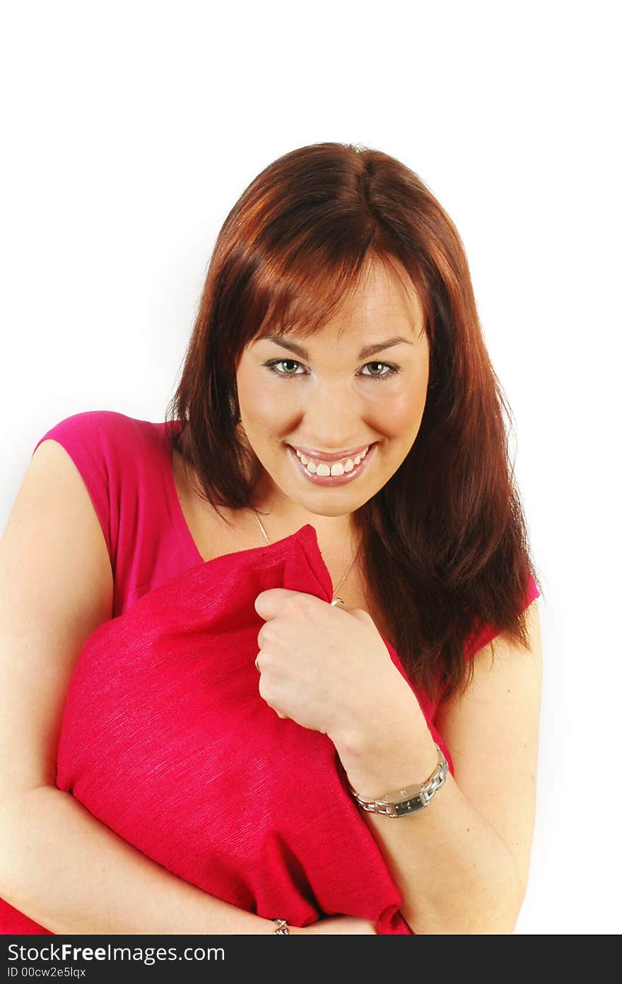 Smiling relaxed brunette, wearing a red top, hugging a cushion, isolated against a white background. Smiling relaxed brunette, wearing a red top, hugging a cushion, isolated against a white background.