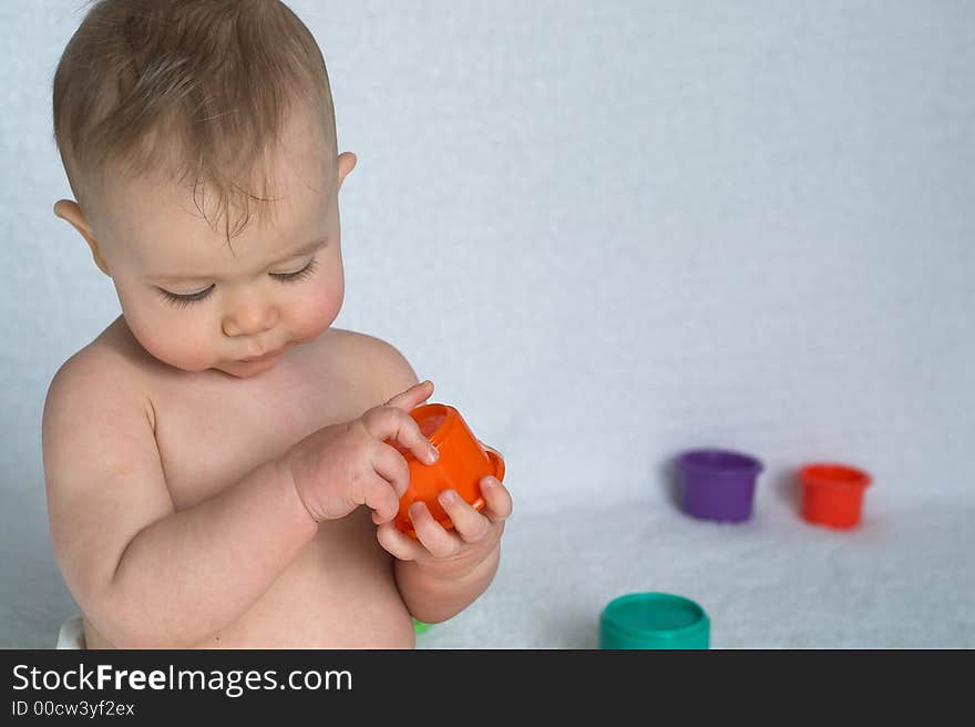 Image of adorable baby playing with stacking cups. Image of adorable baby playing with stacking cups