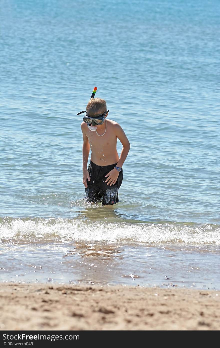 Boy with snorkel coming out the sea. Boy with snorkel coming out the sea