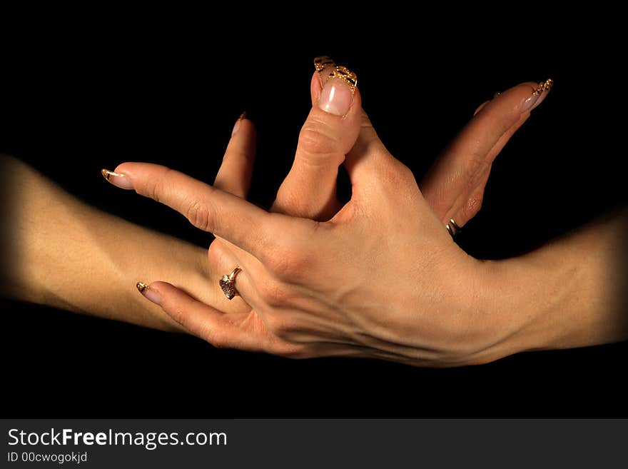 Female hands isolated on black, tungsten lighting used. Female hands isolated on black, tungsten lighting used