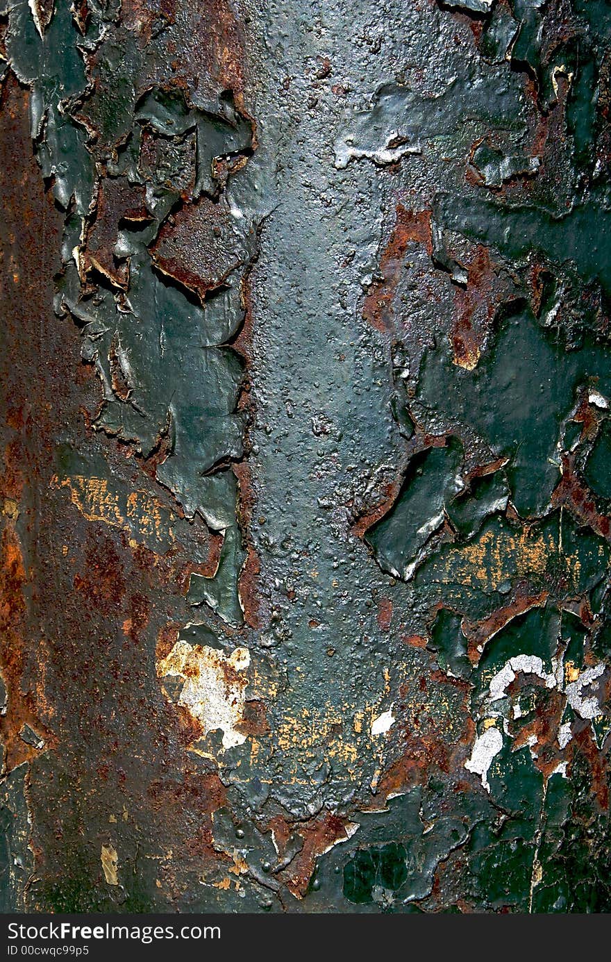 Close up detail of aged utility pole showing the green paint, chipped and peeling, with rust and wrinkles