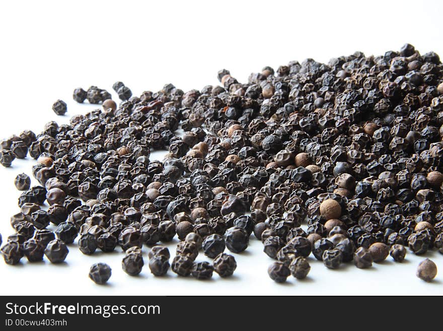 Whole black pepper on white. Whole black pepper on white