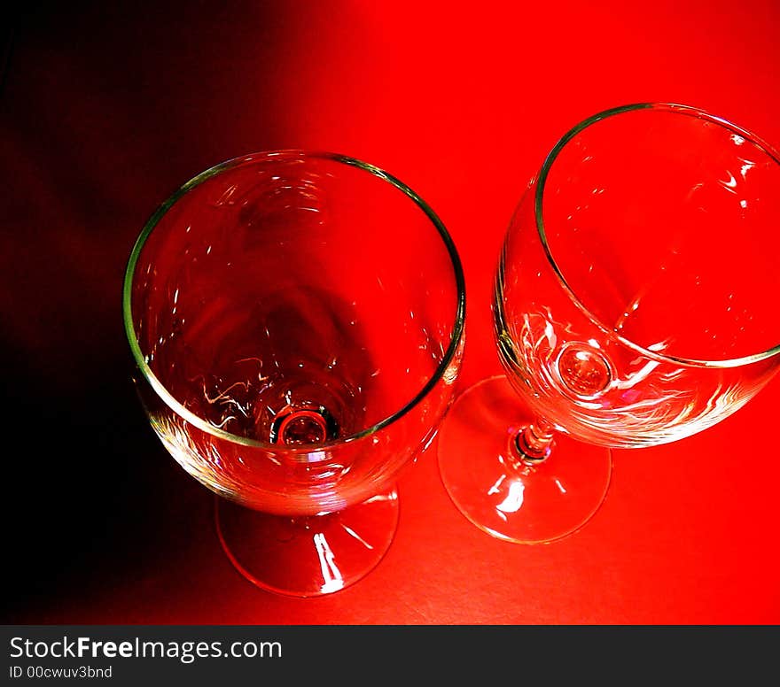 Pair of Wine Glasses Against Red Background