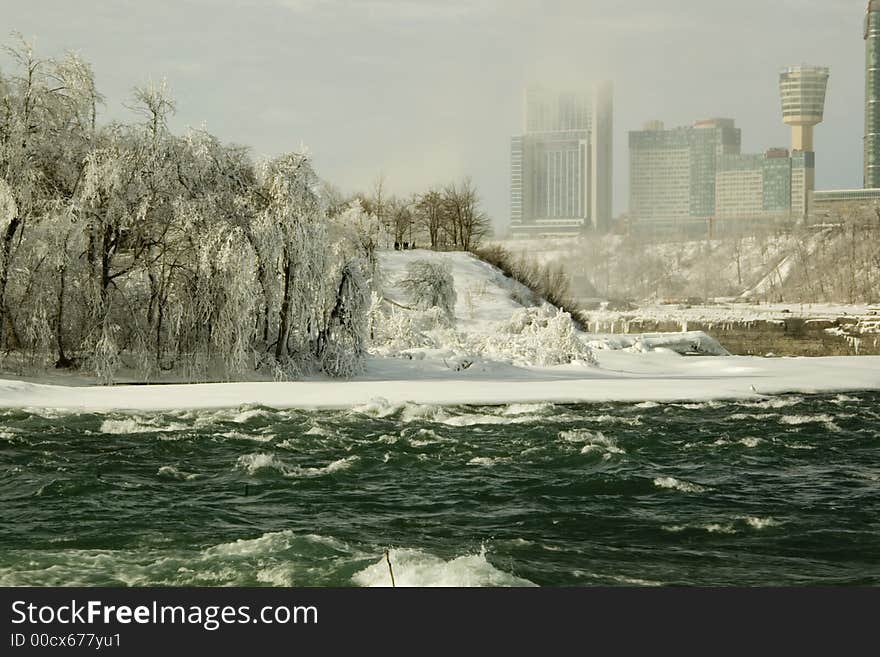 The water rushing towards the Niagara falls in winter time. Ontario Canada visable in the back. The water rushing towards the Niagara falls in winter time. Ontario Canada visable in the back.