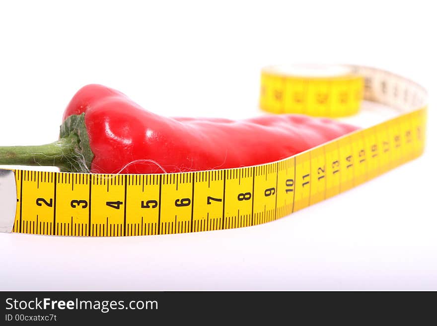 Red pepper with a measurement tape on the white background. Red pepper with a measurement tape on the white background