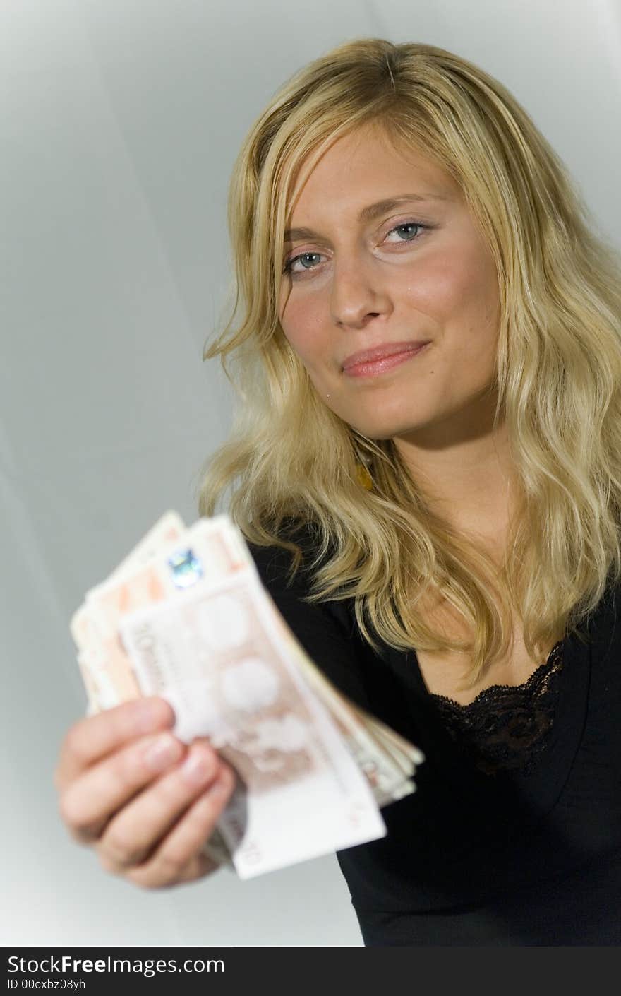 Young blond attractive woman in studio holding money. Young blond attractive woman in studio holding money