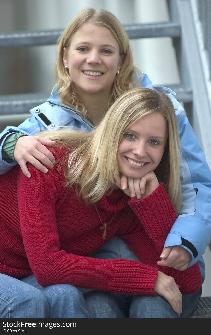 Two young blond women sitting on stairs. Two young blond women sitting on stairs