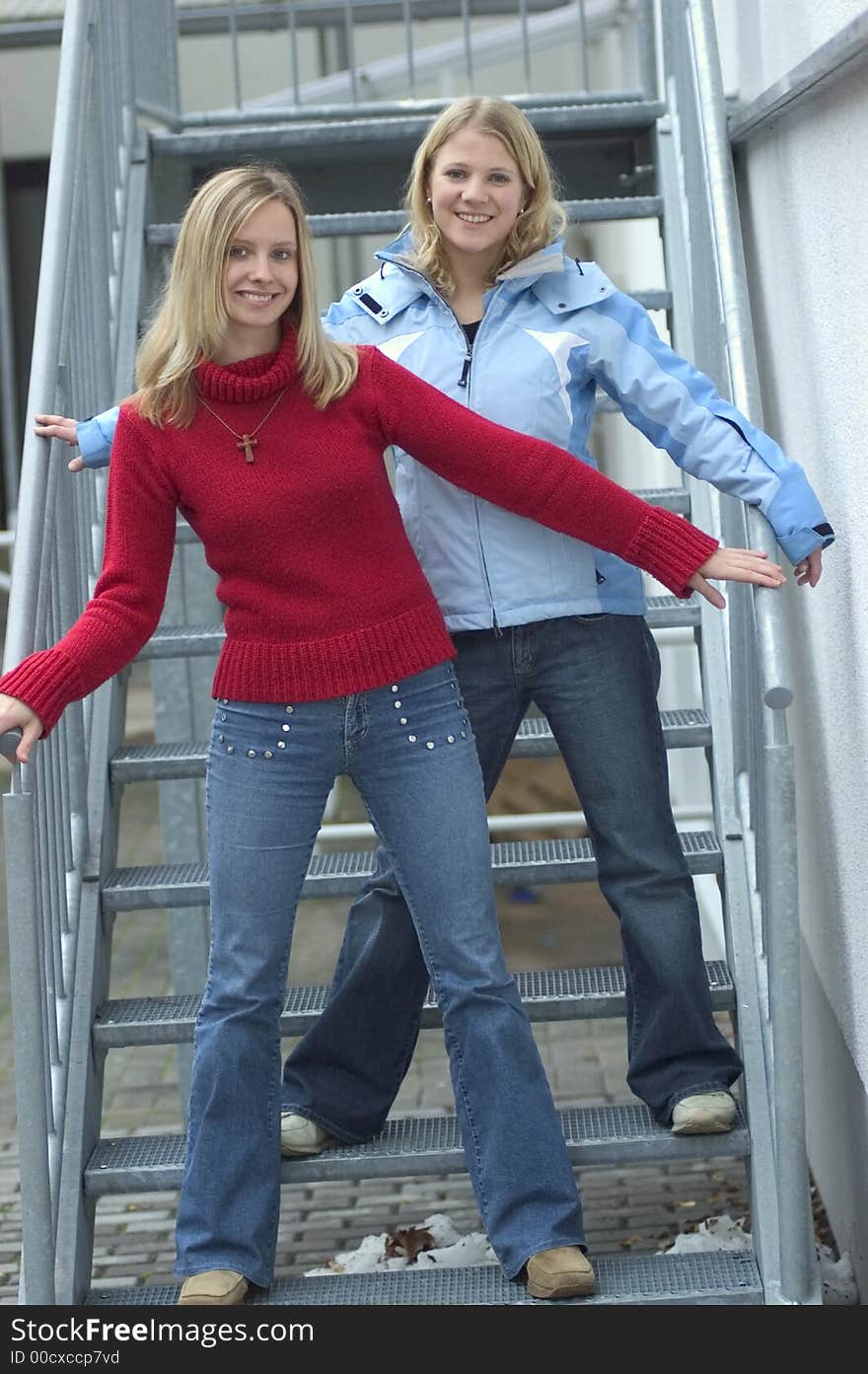 Two young blond women standing on stairs. Two young blond women standing on stairs