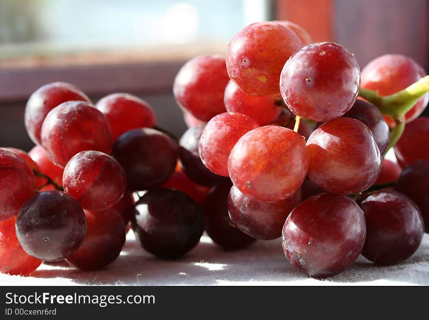 Grapes in sunlight on window sill with copy space