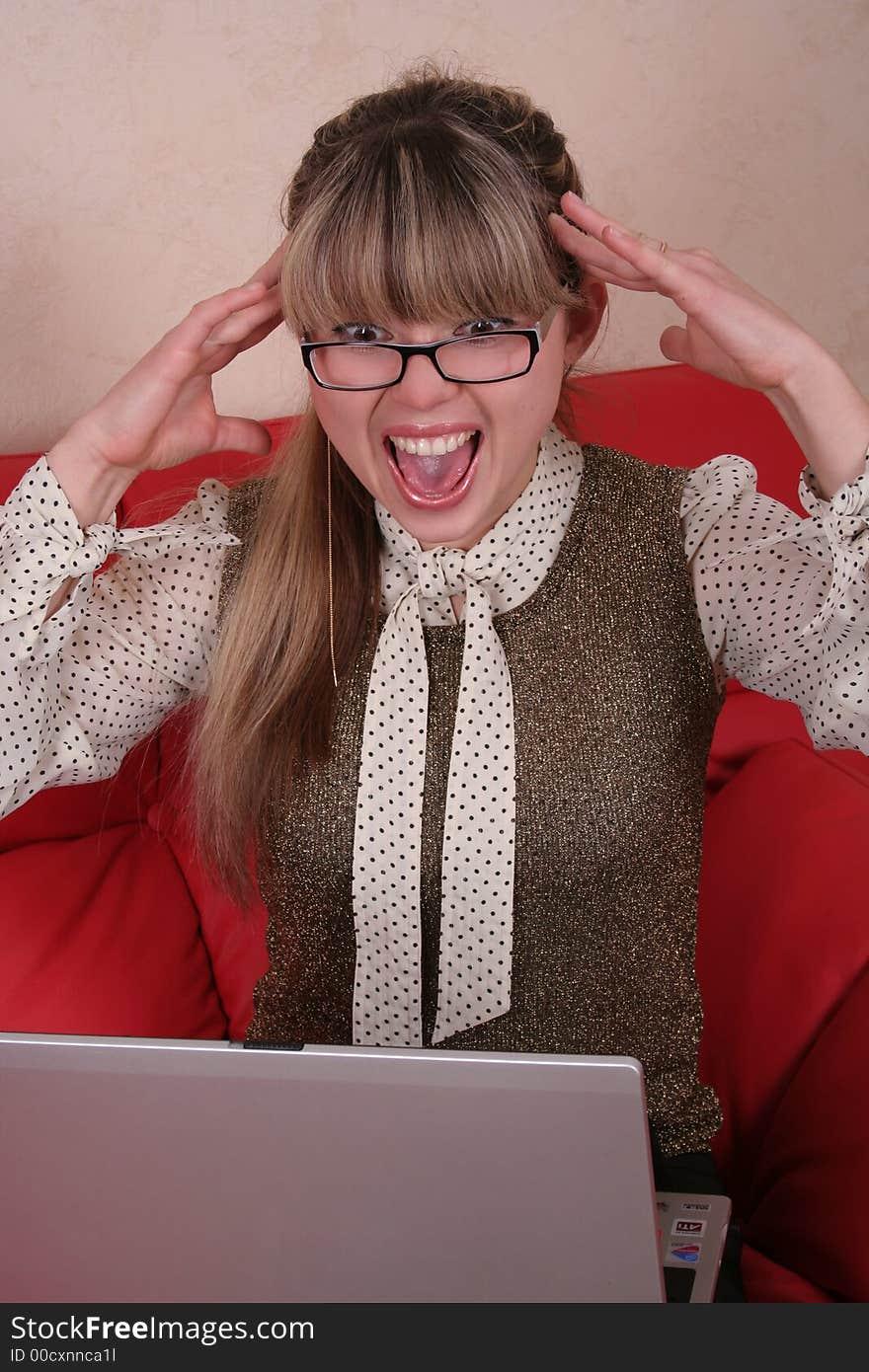 Amazed woman with laptop on red sofa. Amazed woman with laptop on red sofa