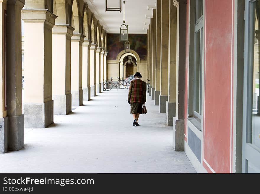 A woman walking between the arches