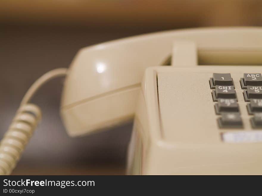 Close up photograph of older biege telephone from the right side. Close up photograph of older biege telephone from the right side.