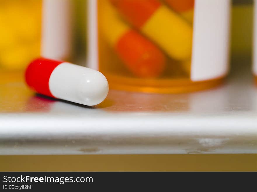 Close up photograph of a medication capsil on a medicine cabinet sil. Close up photograph of a medication capsil on a medicine cabinet sil.