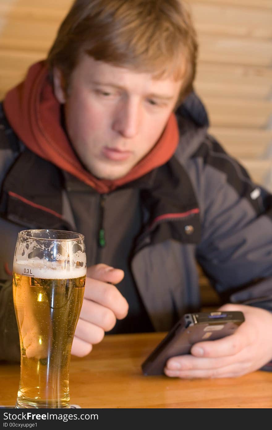 Man with beaker of beer and palm-size computer. Winking and smiling. Man with beaker of beer and palm-size computer. Winking and smiling