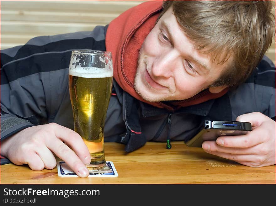 Man with beaker of beer and palm-size computer. Winking and smiling. Man with beaker of beer and palm-size computer. Winking and smiling