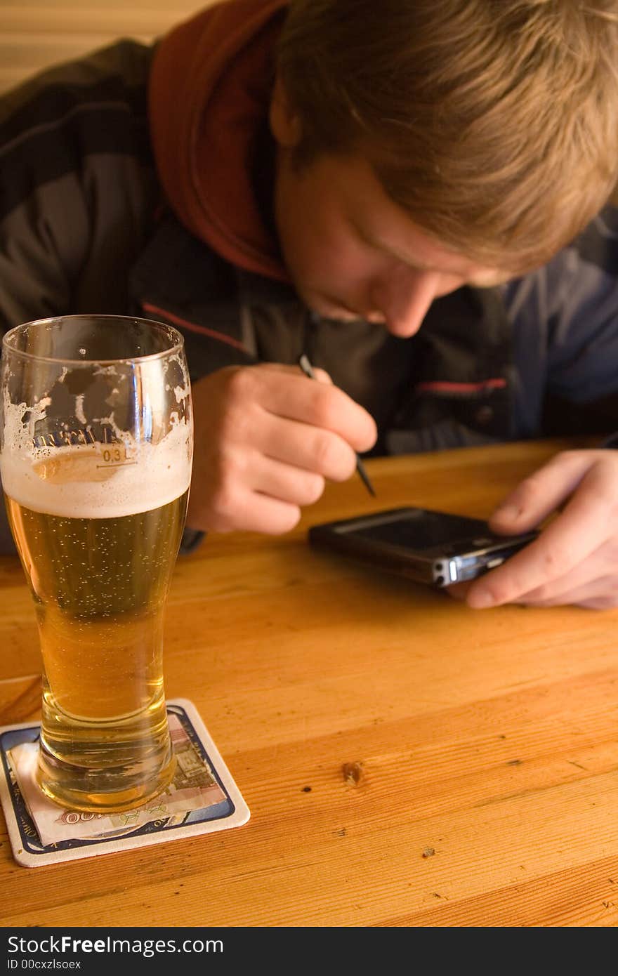 Man with beaker of beer and palm-size computer. Winking and smiling. Man with beaker of beer and palm-size computer. Winking and smiling