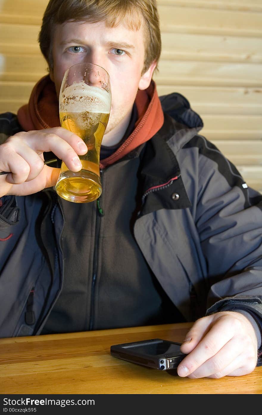 Man with beaker of beer and palm-size computer. Man with beaker of beer and palm-size computer.