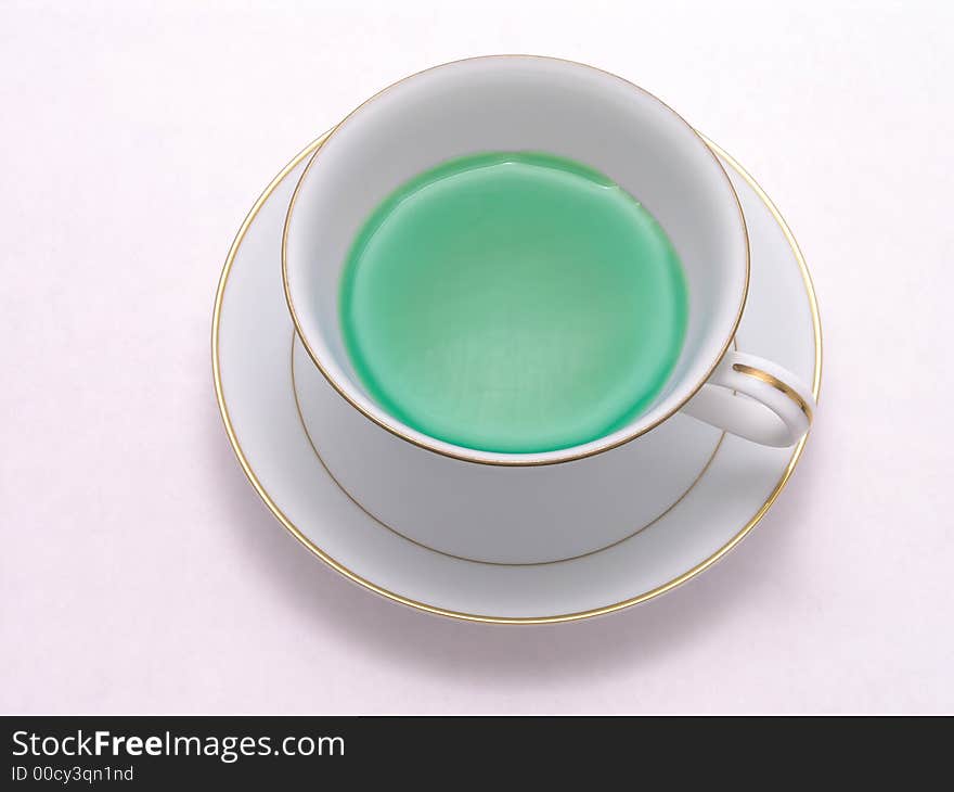 Green Herbal tea in a tea cup on saucer. Green Herbal tea in a tea cup on saucer