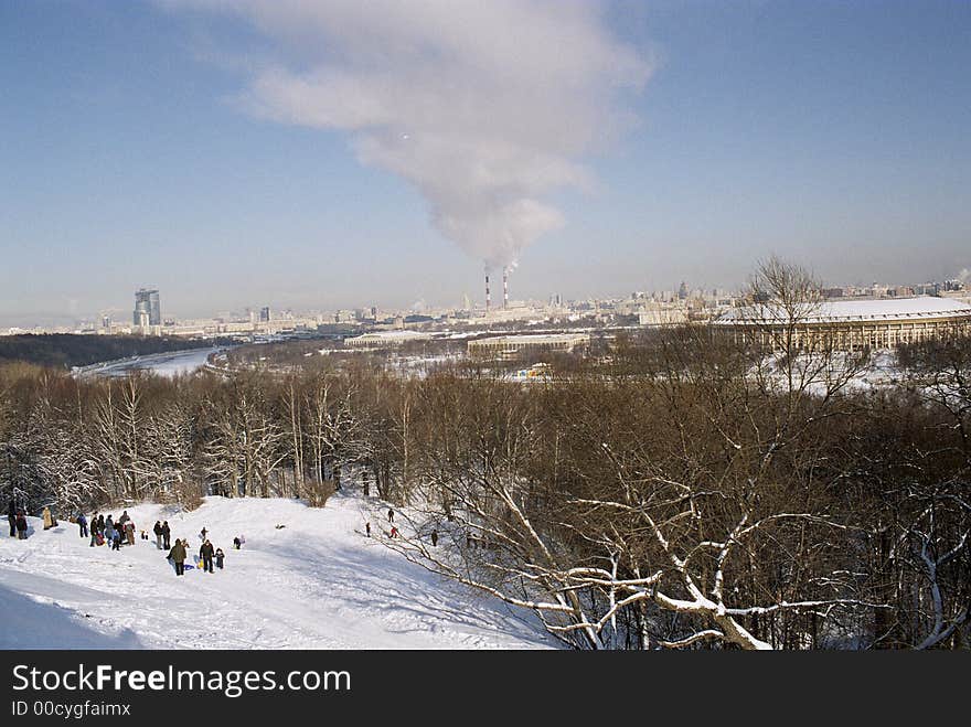 Beautiful view on winter moscow in background big air polution in front children on hill. Beautiful view on winter moscow in background big air polution in front children on hill