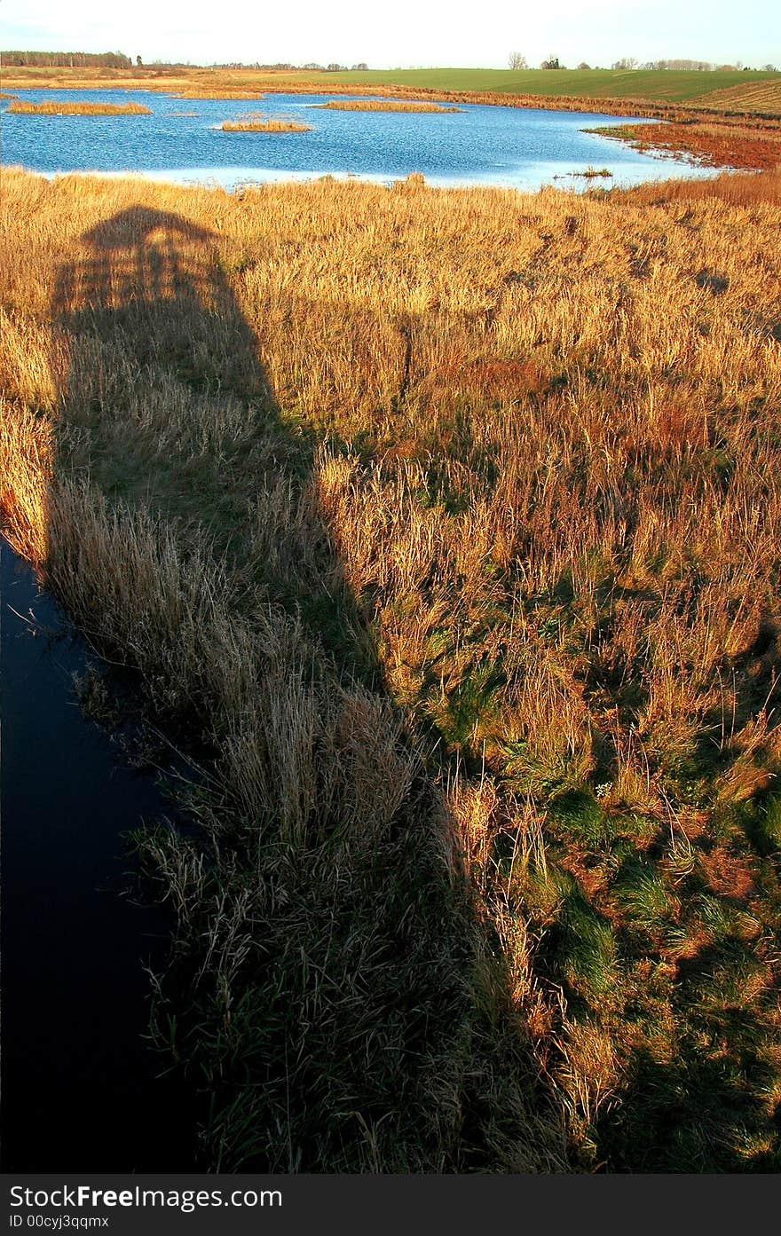 High tower made of shadow on the lake