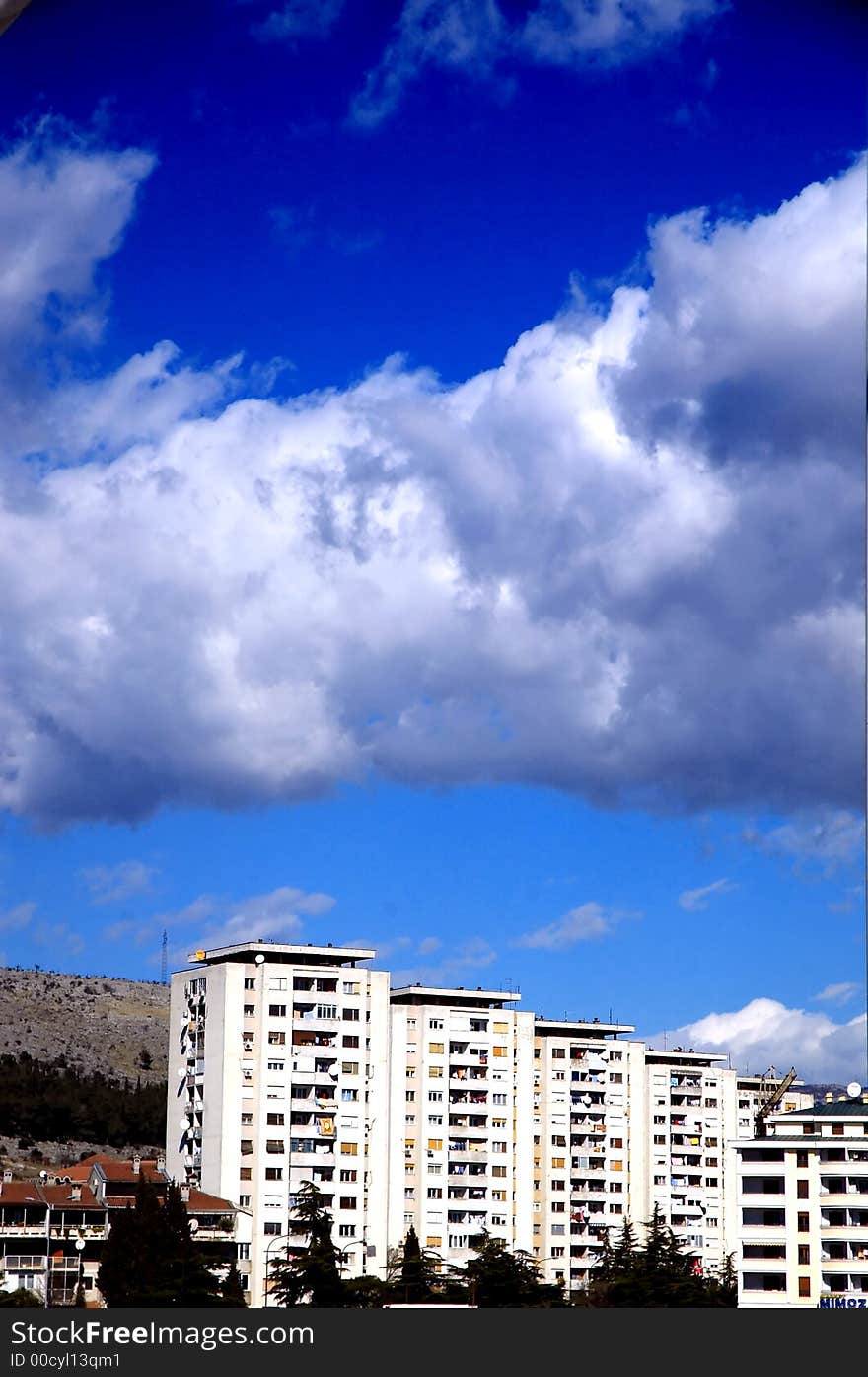 Skyscrapers and heawy clouds on the blue sky.